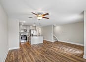 Thumbnail 4 of 24 - A spacious room with a ceiling fan and wooden flooring.