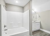 Thumbnail 16 of 24 - A white bathroom with a tub and a vanity.