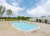 Thumbnail 21 of 24 - A large outdoor swimming pool surrounded by a fence.