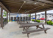 Thumbnail 22 of 24 - A covered picnic area with tables and benches.