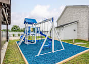 Thumbnail 23 of 24 - A playground with a blue slide and a white frame.