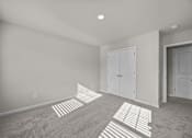 Thumbnail 13 of 29 - A room with a carpet and two white doors.