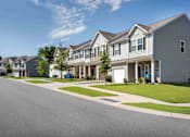 Thumbnail 2 of 29 - A row of houses with a clear blue sky above them.