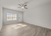 Thumbnail 21 of 29 - A room with a ceiling fan and wooden flooring.