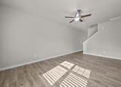 Thumbnail 23 of 29 - A room with a ceiling fan and wooden flooring.