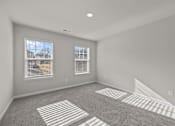 Thumbnail 5 of 29 - A room with a carpeted floor and two windows.