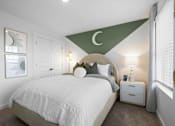 Thumbnail 42 of 49 - A bedroom with a white bed and a green triangular design on the wall.