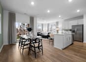 Thumbnail 26 of 49 - A modern kitchen with a dining table and chairs.