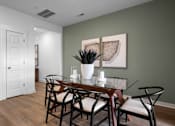 Thumbnail 27 of 49 - A dining room with a glass table and chairs.