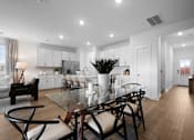 Thumbnail 28 of 49 - A modern dining room with a glass table and chairs.