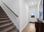 Thumbnail 43 of 49 - A hallway with a staircase and a door.