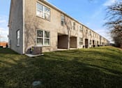 Thumbnail 46 of 49 - A long building with a green lawn in front.