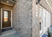 Thumbnail 19 of 49 - A house numbered 101 with a brown door and a blue mat on the floor.