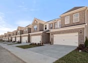 Thumbnail 18 of 49 - A row of houses with garages in front.