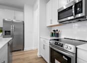 Thumbnail 22 of 49 - A modern kitchen with stainless steel appliances and white cabinets.