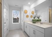 Thumbnail 32 of 49 - A bathroom with white cabinets and a large mirror.
