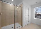 Thumbnail 36 of 49 - A bathroom with a walk-in shower and a white door.