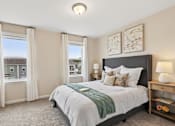Thumbnail 6 of 16 - A bedroom with a large bed and a window with curtains.