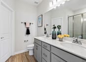 Thumbnail 7 of 16 - A bathroom with a white toilet, a sink, and a mirror.