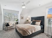 Thumbnail 11 of 13 - A bedroom with a bed, chair, and ceiling fan.