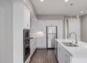 Thumbnail 11 of 50 - a kitchen with white cabinets and stainless steel appliances