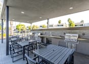 Thumbnail 46 of 46 - A patio with a grill and seating area.
