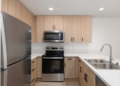 Thumbnail 18 of 50 - a kitchen with stainless steel appliances and wooden cabinets