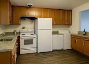 Thumbnail 10 of 11 - A kitchen with wooden cabinets and white appliances.
