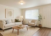 Thumbnail 3 of 11 - A living room with a couch, chair, and coffee table.