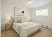 Thumbnail 4 of 11 - A bedroom with a bed, nightstands, and a painting on the wall.