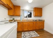 Thumbnail 8 of 11 - A kitchen with wooden cabinets and a white stove.