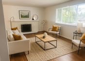 Thumbnail 8 of 13 - A living room with a fireplace, two chairs, and a coffee table.