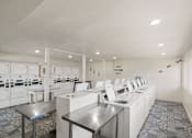 Thumbnail 20 of 20 - Community laundry facility with folding tables at Skyline at Barton Creek Apartments, Texas, 78758
