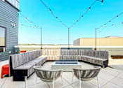 Thumbnail 6 of 23 - A patio with a bench, chairs, and string lights.