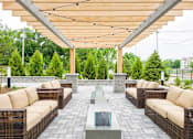 Thumbnail 7 of 23 - A patio with a table and chairs under a roof.