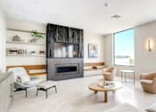 Thumbnail 13 of 23 - A modern living room with a fireplace and a view of the outdoors.