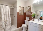 Thumbnail 5 of 23 - A bathroom with a toilet, sink, and shower.