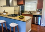 Thumbnail 4 of 34 - A kitchen with a blue counter and a stove.