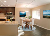 Thumbnail 3 of 34 - A modern kitchen with a dining table and chairs.