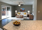 Thumbnail 1 of 34 - A bowl of oranges sits on a counter in a well-lit room.