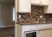 Thumbnail 14 of 23 - a kitchen with white cabinets and a counter top and a sink
