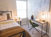 Thumbnail 42 of 54 - a bedroom with a bed and a desk with a chair
