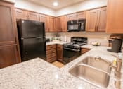 Thumbnail 39 of 54 - a kitchen with black appliances and granite counter tops