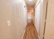 Thumbnail 53 of 54 - a long hallway with wood floors and white closets and doors
