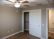 Thumbnail 17 of 19 - A room with a white door and a ceiling fan.