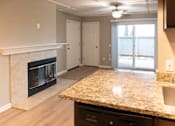Thumbnail 19 of 19 - A kitchen with a granite countertop and a fireplace.