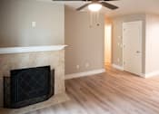 Thumbnail 9 of 19 - A living room with a fireplace and a ceiling fan.