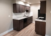 Thumbnail 8 of 19 - A kitchen with dark brown cabinets and a white countertop.