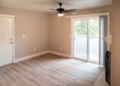 Thumbnail 11 of 19 - A room with a ceiling fan and sliding glass doors.