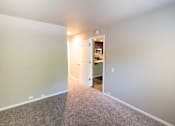 Thumbnail 23 of 56 - A room with a carpeted floor and a doorway leading to another room.